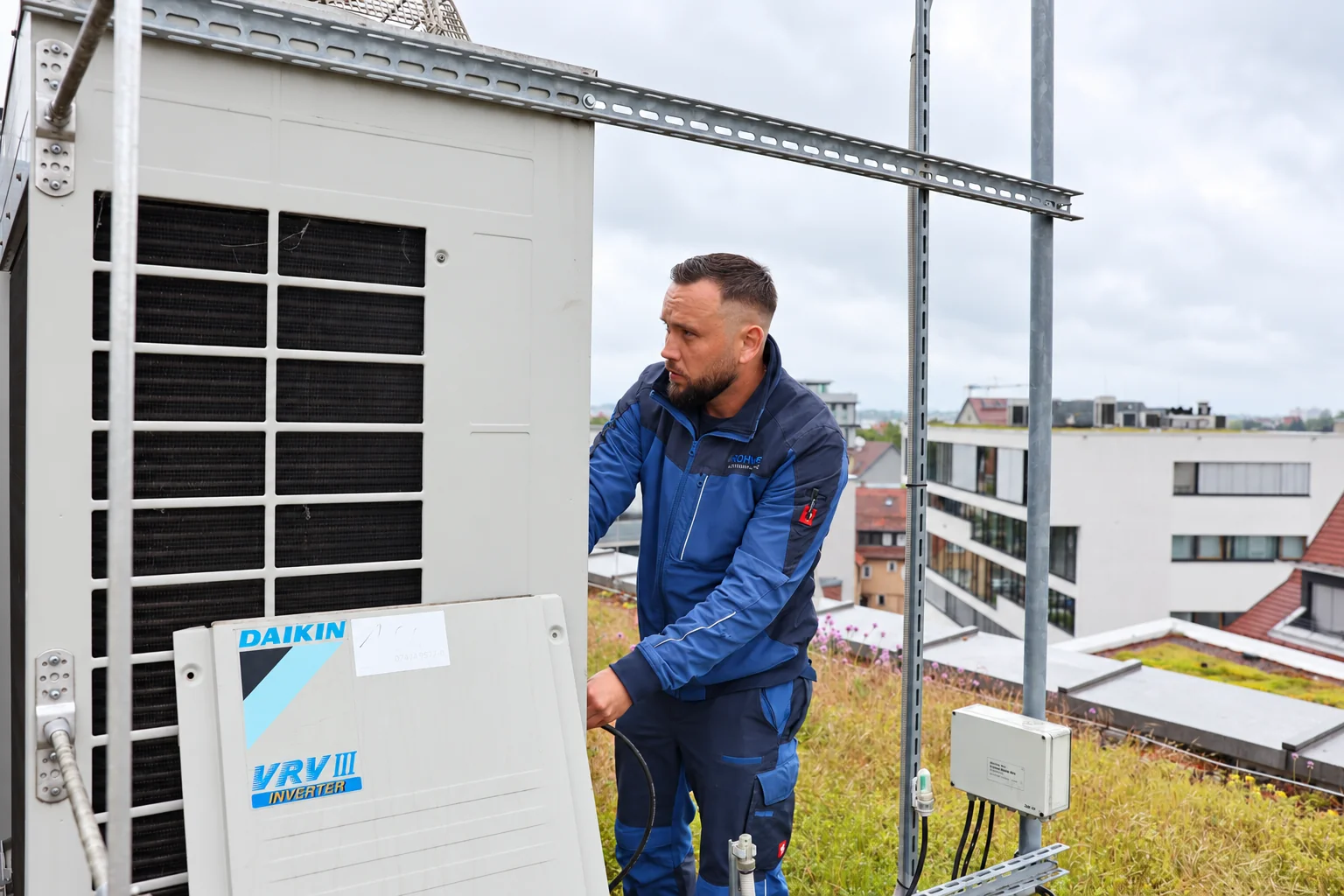 Techniker neben einer klimatechnischen Anlage
