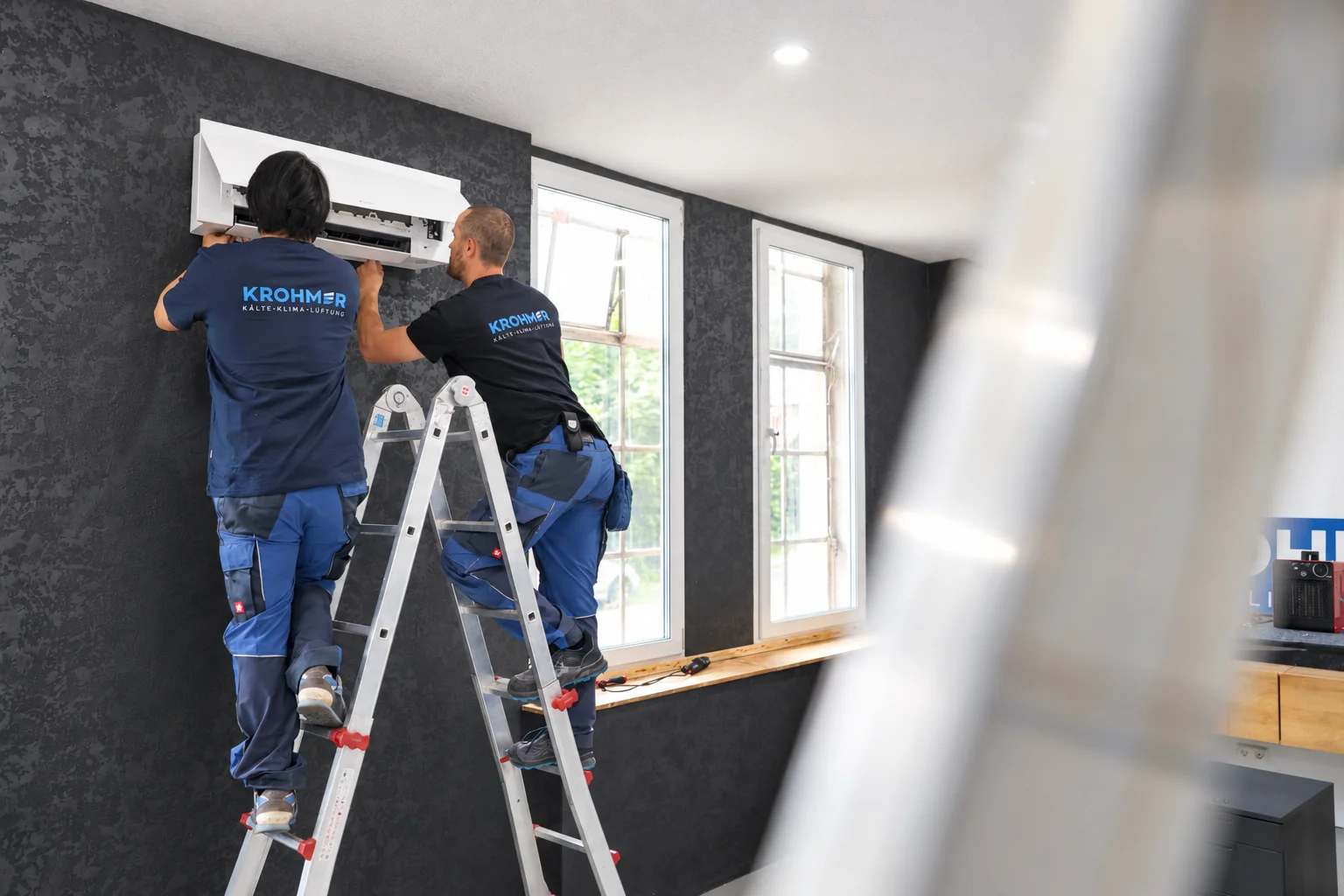 Zwei Krohmer-Mitarbeiter bei der Installation im Wohnraum