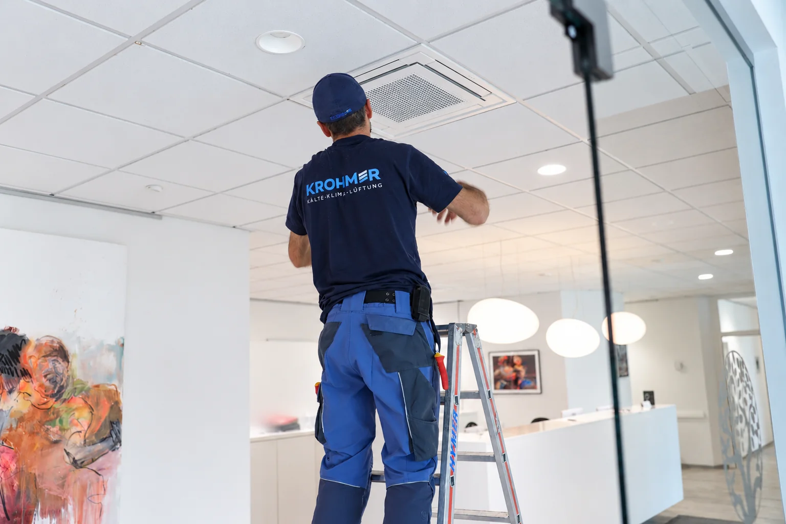 Techniker beim Einsetzen der Abdeckung eines Deckengeräts