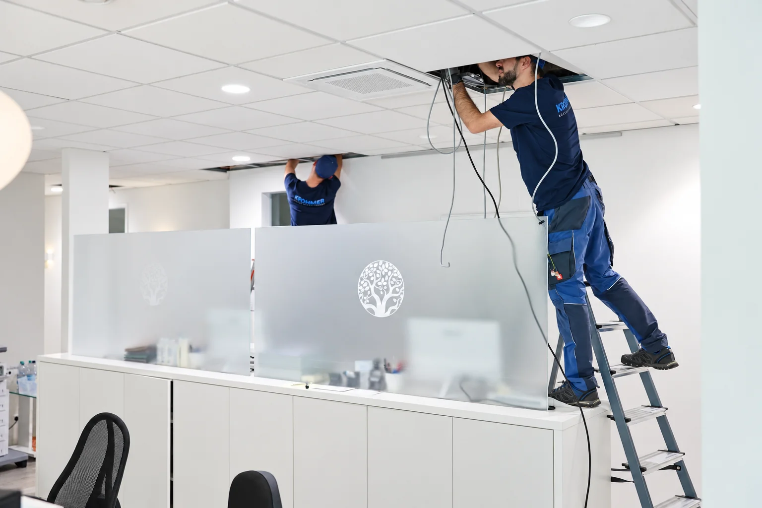 Krohmer-Techniker arbeitet an der Deckenanlage am Praxisempfang