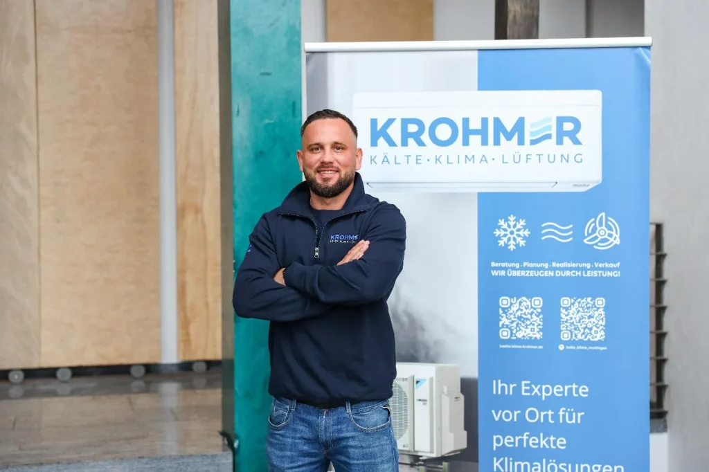 Mitarbeiter vor einem Krohmer-Firmenbanner