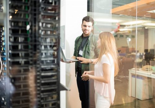 Zwei IT-Experten im Rechenzentrum vor Serverinfrastruktur